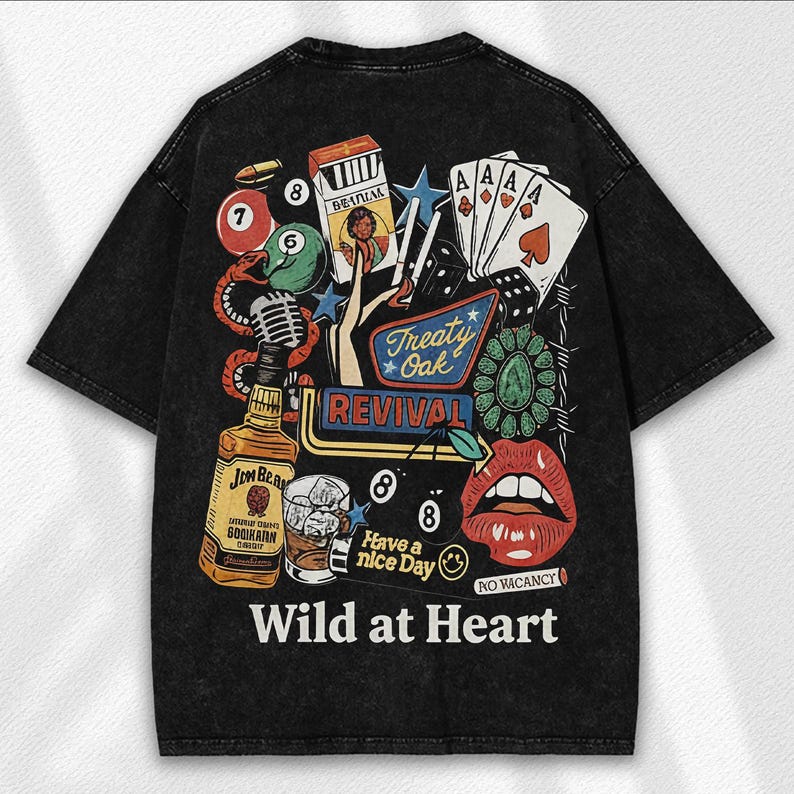 May include: Black graphic t-shirt with a vintage-style design. The design includes playing cards, dice, a bottle of whiskey, a microphone, and the words "Wild at Heart". The shirt has a distressed look.