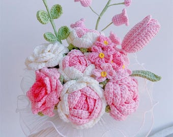 May include: A handmade crochet bouquet featuring pink, white, and yellow flowers with green leaves. The bouquet includes roses, tulips, and other floral elements. The bouquet is held together with a white, lacy fabric. The text "Pattern PDF" is visible.
