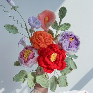 Könnte beinhalten: Ein handgefertigter Häkelblumenstrauß mit einer Vielzahl bunter Blumen. Der Strauß enthält rote, orangefarbene, rosa, lila und weiße Blumen mit grünen Blättern. Der Text "Pattern PDF" ist sichtbar.