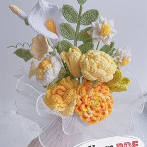 Könnte beinhalten: Ein handgefertigter Häkelstrauß mit weißen Calla-Lilien, gelben Rosen und anderen bunten Blumen. Der Strauß ist in weißem, gerüschtem Stoff verpackt. Der Text "Pattern PDF" ist sichtbar.