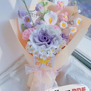 Könnte beinhalten: Ein handgefertigter Blumenstrauß aus Häkelblumen in Lila, Rosa, Weiß und Gelb, verpackt in pfirsichfarbenem Papier und mit einer rosa Schleife gebunden. Der Strauß enthält eine Vielzahl von Blumenarten, darunter Rosen und Calla-Lilien.