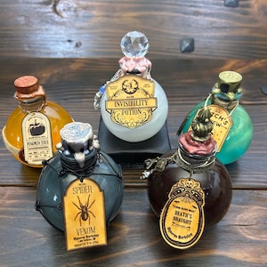 May include: Five decorative potion bottles with unique labels and stoppers. The bottles are filled with various colored liquids, including orange, white, green, and brown. Each bottle has a distinct label with text such as "Pumpkin Juice" and "Spider Venom".
