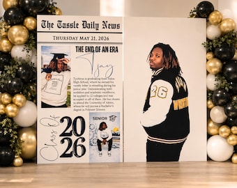 May include: A large graduation display board titled The Tassle Daily News, dated Thursday May 21, 2026, featuring photos of a graduate, text about academic achievements, and the number 2026, flanked by decorative black, gold, and white balloon arches.