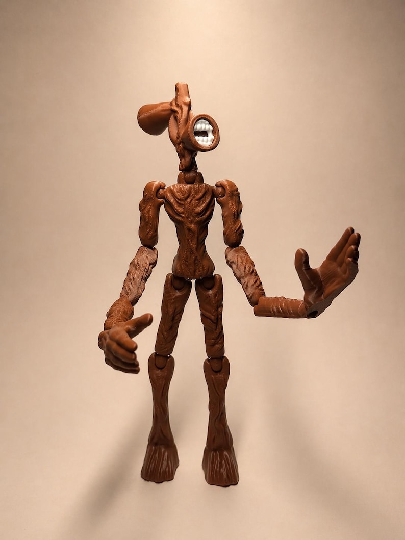 Puede incluir: Figura de acci&oacute;n de Siren Head marr&oacute;n con articulaciones. La figura tiene una cabeza en forma de sirena con una boca con dientes blancos. Los brazos de la figura est&aacute;n extendidos y las piernas est&aacute;n de pie. La figura es de pl&aacute;stico.
