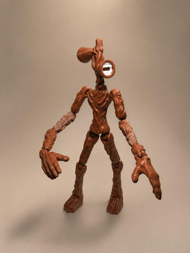 Puede incluir: Figura de acci&oacute;n de Siren Head marr&oacute;n con articulaciones. La figura tiene un dise&ntilde;o &uacute;nico, con una cabeza en forma de sirena y un cuerpo humanoide delgado. La figura posa con los brazos extendidos, mostrando su detallada artesan&iacute;a.