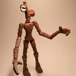 Puede incluir: Figura de acci&oacute;n de Siren Head marr&oacute;n con articulaciones. La figura tiene una cabeza con forma de sirena con boca blanca. Los brazos est&aacute;n extendidos y la figura est&aacute; sobre un fondo neutro.