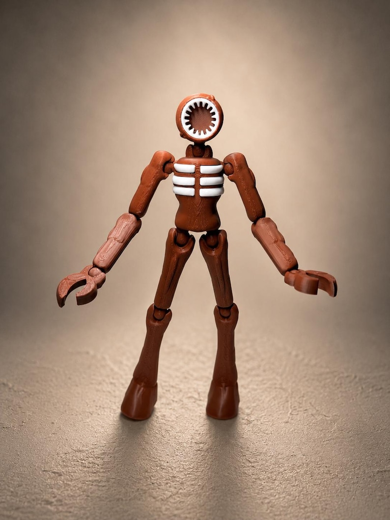 May include: A brown articulated figure with a siren-shaped head and white accents on the chest. The figure has jointed arms and legs, and claw-like hands. The toy is posed against a neutral background.