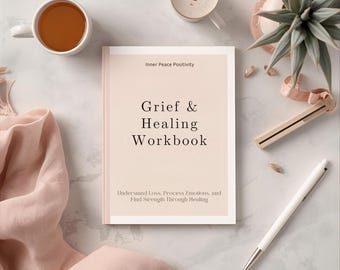 May include: A workbook titled "Grief & Healing Workbook" with the text "Inner Peace Positivity" at the top. The book is on a marble surface, with a cup of tea, a pen, and a plant. The book's subtitle reads: "Understand Loss, Process Emotions, and Find Strength Through Healing."