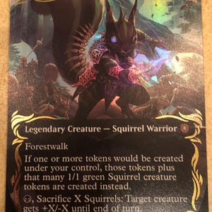 May include: A holographic Magic: The Gathering trading card titled Chatterfang, Squirrel General. The card features a dark, armoured squirrel warrior illustration, gold filigree borders, and game text detailing its abilities as a legendary creature.