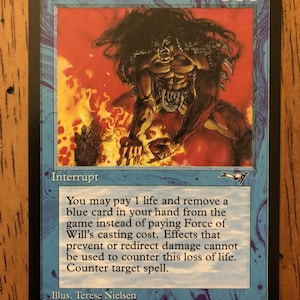 以下が含まれることがあります： マジック：ザ・ギャザリングのカード「Force of Will」。カードには、筋肉質な人物と燃えるような背景が描かれています。「Interrupt」とゲームの説明文が含まれています。カードは青色で、黒い縁取りがあります。1996年製。