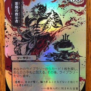 May include: A holographic trading card featuring a demonic figure with horns and a muscular build, set against a backdrop of red and silver splatters. Japanese text is visible, along with the number 1 and a skull symbol.
