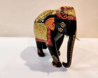 Estatua de elefante pintada a mano en madera de kadam negra: fuerza y fe