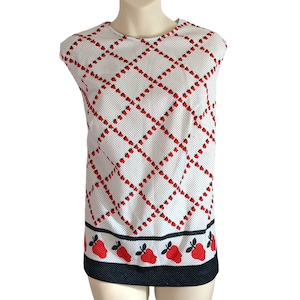 May include: White sleeveless dress with a red and black diamond pattern and a black and red strawberry border.