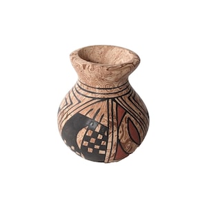 May include: A small, brown, black, and red ceramic vase with geometric patterns. The vase has a rounded body and a wide opening.