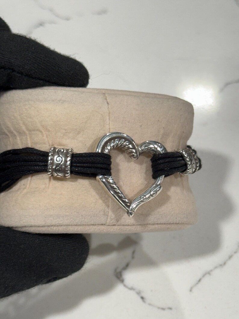 K&ouml;nnte beinhalten: Eine wei&szlig;e Keramik-Tasse mit schwarzem Henkel und dem Text "But First, Coffee" in fetter, schwarzer Schrift. Die Tasse steht vor einem neutralen Hintergrund, der ihr schlichtes Design hervorhebt.