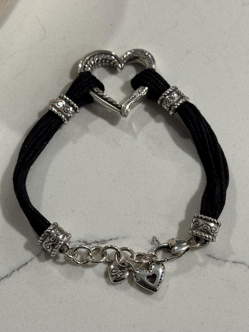 K&ouml;nnte beinhalten: Eine wei&szlig;e Keramiktasse mit schwarzem Henkel und dem Text "But First, Coffee" in schwarzer, handschriftlicher Schrift. Die Tasse steht auf einer wei&szlig;en Oberfl&auml;che.