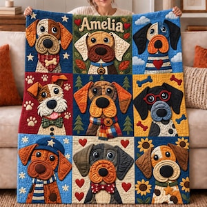 May include: A rectangular quilt featuring a grid of nine squares, each displaying a different dog illustration with various accessories like scarves, hats, and glasses. The top center square includes the name Amelia in decorative lettering.