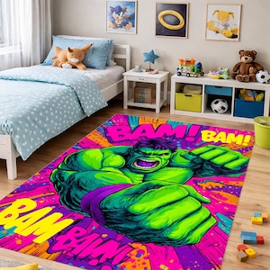 Könnte beinhalten: Ein lebendiger, rechteckiger Teppich mit einer großen Illustration von Hulk. Der Hulk ist grün mit lila Shorts, vor einem Hintergrund aus rosa, lila und gelbem "BAM!" Text und Spritzern. Der Teppich befindet sich in einem Kinderzimmer.