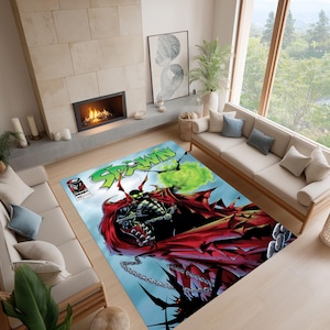 May include: A rectangular area rug featuring a comic book cover design. The rug displays the word "SPAWN" in green, with a central illustration of a character in a red cape and black armor. The background is a light blue with a green energy effect.