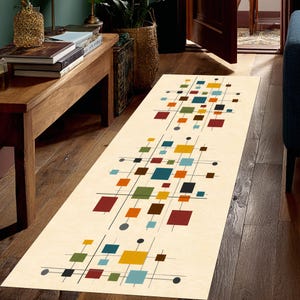 May include: A long rectangular runner rug with a cream-colored background featuring a repeating geometric pattern of thin black lines, small black circles, and solid squares in shades of red, yellow, teal, olive green, and dark brown.