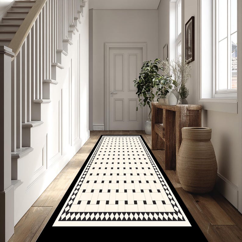 May include: A hallway runner rug with a geometric pattern in black and cream. The rug features a border of black and white triangles and a central design of alternating squares and rectangles. The rug is placed on a wooden floor.