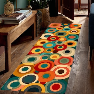 May include: A rectangular rug with a retro design featuring overlapping circles in shades of orange, yellow, teal, and red. The rug is placed on a wooden floor, adding a pop of colour to the space.