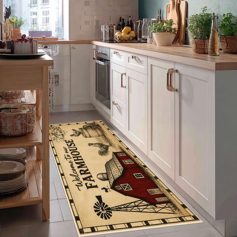 May include: A rectangular kitchen runner rug featuring a cream-colored background with a black border. The design includes a red barn, a windmill, a rooster, and a wooden barrel, with the black text "Welcome to our FARMHOUSE" printed on it.