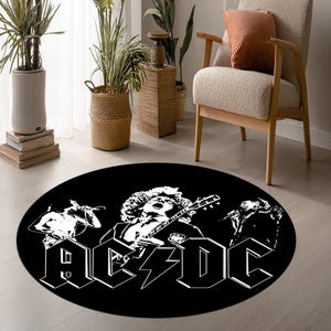以下が含まれることがあります： AC/DCのバンドの白いグラフィックが特徴の黒い円形ラグ。ラグには、稲妻のデザインと太字の白い文字でバンド名が表示されています。ラグには、バンドメンバーのイラストも表示されています。