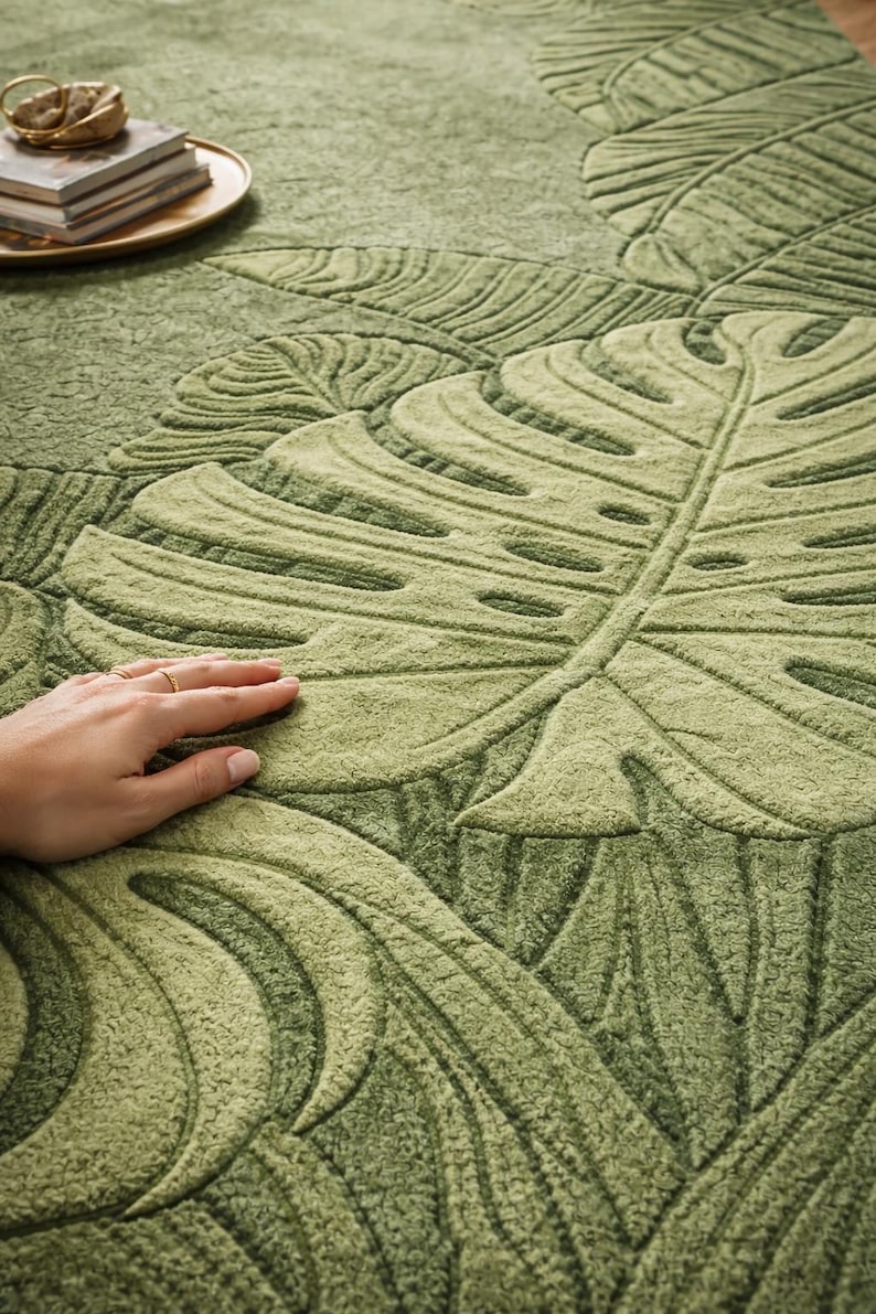 Hand tufted green leaf area rug in modern American living room
Botanical wool rug with raised leaf texture close-up detail
Modern green area rug styled with sofa and coffee table