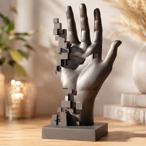 Peut inclure: Une sculpture noir mat représentant une main humaine ouverte sur une base rectangulaire. Le côté gauche de la main semble se désintégrer en une série de petits cubes noirs solides, créant un effet visuel géométrique et fragmenté.