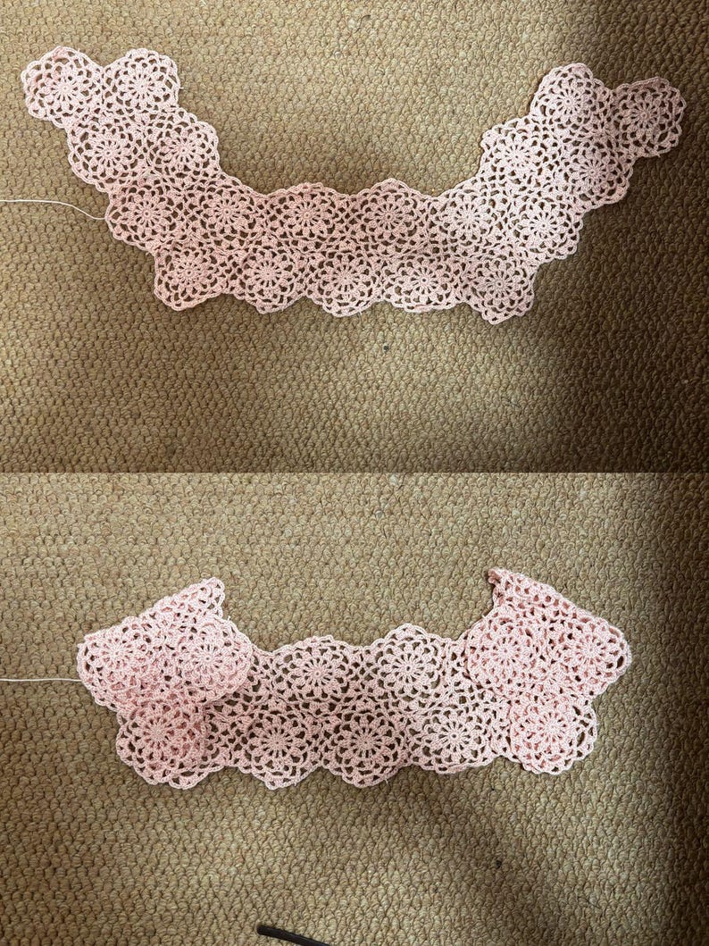 May include: Two handmade, light pink crochet collars. The collars are made of delicate, floral-patterned lace. The collars are displayed on a brown surface.