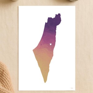May include: A print featuring a stylized map of Israel, rendered in gradient colors of purple, orange, and yellow. A small white heart is placed within the map. The print is on white paper.