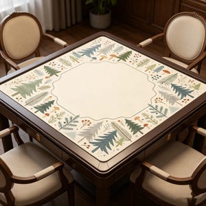 May include: A square wooden game table with a cream-colored surface and a decorative border featuring stylized trees, mushrooms, and berries in green, blue, and brown. The table is surrounded by four chairs with cream-colored seats and wooden frames.