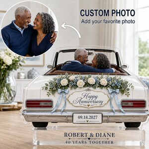 May include: A custom acrylic anniversary display featuring a white convertible car model decorated with blue and white flowers, ribbons, and a sign reading Happy Anniversary and 09.18.2027. The base is engraved with ROBERT & DIANE 40 YEARS TOGETHER.