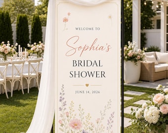 May include: A vertical rectangular bridal shower welcome sign on a black metal stand with white fabric draped over the top. The cream-colored sign features floral illustrations and the text: Welcome to Sophia's Bridal Shower, June 14, 2026.