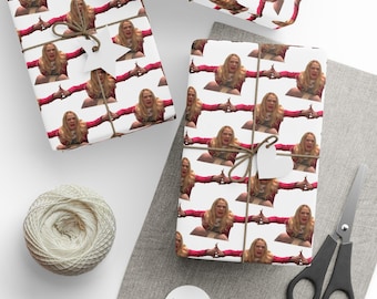 May include: Gift wrap with a repeating pattern of a woman in a red jacket with outstretched arms. The wrapped gifts are tied with twine and heart-shaped tags. A ball of twine and scissors are also visible.
