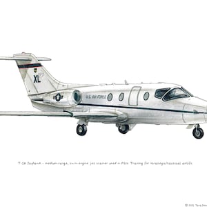 Könnte beinhalten: Ein weißes T-1A Jayhawk Jet-Trainingsflugzeug mit dem Text "XL" und "US AIR FORCE" an der Seite. Das Flugzeug steht am Boden mit ausgefahrenem Fahrwerk.