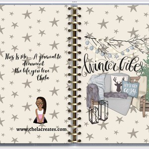 Peut inclure: Un journal à spirales avec une couverture beige clair ornée d'un motif d'étoiles. Le journal comprend le texte "This Is Me... A journal to document the life you love." et "Winter Vibes." Une scène d'hiver douillette est illustrée.