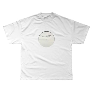 Op de afbeelding: Een wit t-shirt met een cirkelvormig ontwerp dat lijkt op een cd. Het ontwerp heeft de tekst "FKA twigs" gedrukt in een lettertype in typemachinestijl. Het shirt is gemaakt van een zacht materiaal en heeft een ronde hals.