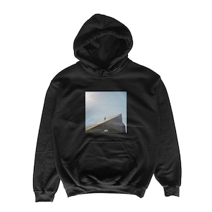 May include: Black hooded sweatshirt with a front pocket and a drawstring hood. The sweatshirt features a square graphic on the front depicting a person standing on a building with a blue sky background. The sweatshirt is made of a soft material.