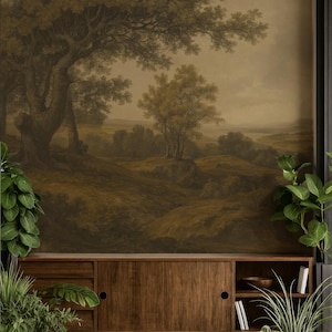 May include: A wooden sideboard with sliding doors and open shelving, positioned against a wall featuring a large-scale mural of a sepia-toned landscape with trees and rolling hills, accompanied by several potted green plants in the foreground.