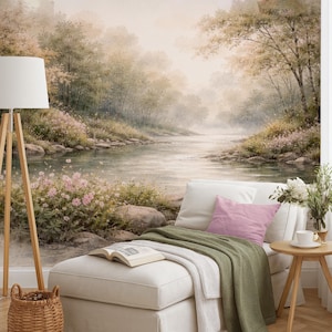 May include: A white chaise lounge with a green throw blanket and an open book, positioned before a wall mural of a misty river landscape with pink flowers, green trees, and rocks. A floor lamp and a small wooden side table are nearby.
