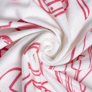 a close-up view of a white towel with red text or patterns on it, twisted and curled in a spiral motion.