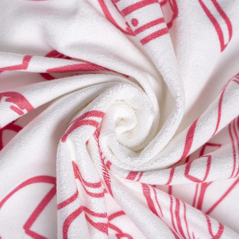a close-up view of a white towel with red text or patterns on it, twisted and curled in a spiral motion.