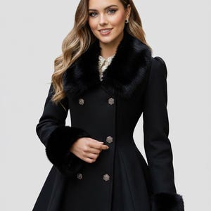 May include: A black double-breasted coat with a faux fur collar and cuffs. The coat features decorative silver buttons and a flared skirt. The model is wearing the coat. The coat is a classic style.