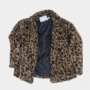 Puede incluir: Abrigo de piel sint&eacute;tica con estampado de leopardo en tonos marr&oacute;n y negro. El abrigo tiene un forro acolchado negro y un cuello cl&aacute;sico. Una etiqueta en blanco est&aacute; adjunta cerca del cuello.