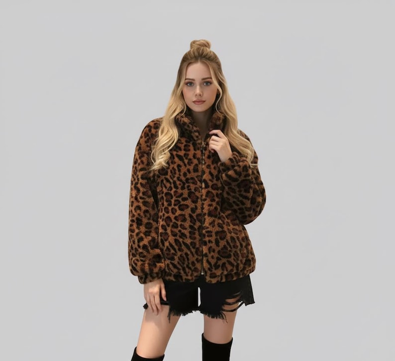 Puede incluir: Chaqueta con estampado de leopardo marr&oacute;n y negro, con cierre de cremallera. La chaqueta tiene cuello alto y mangas largas. La modelo lleva shorts negros y botas negras.