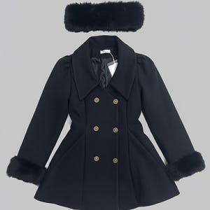 May include: A black double-breasted coat with a wide collar, long sleeves featuring black faux fur cuffs, and six gold-toned buttons. The coat has a flared hem and is paired with a matching black faux fur headband accessory.