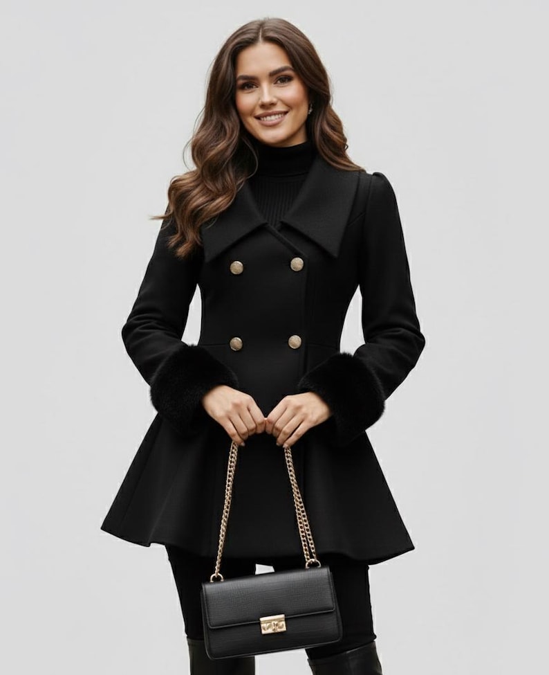 May include: A black double-breasted coat with gold buttons and faux fur cuffs. The coat has a flared skirt and a wide collar. A black purse with a gold chain is held in the hands.