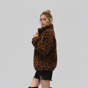 Puede incluir: Chaqueta con estampado de leopardo marr&oacute;n y negro con cuello alto. La chaqueta est&aacute; hecha de un material suave y afelpado. La modelo lleva un pantal&oacute;n corto negro.